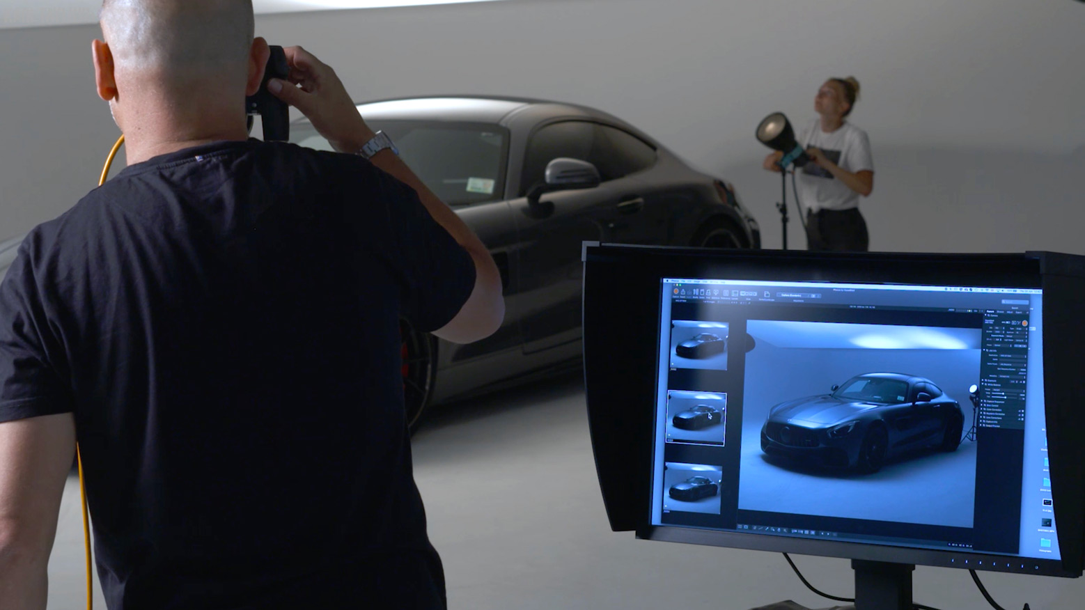 Karl overseeing an assistant moving lights during a car photoshoot